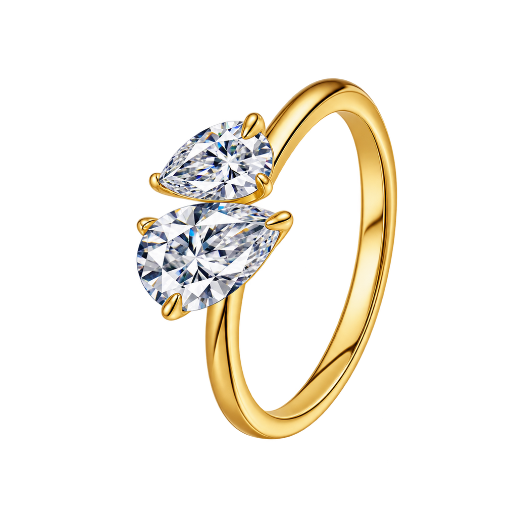 A gold ring featuring two pear-cut clear gemstones in a staggered setting, shown on a plain white background.