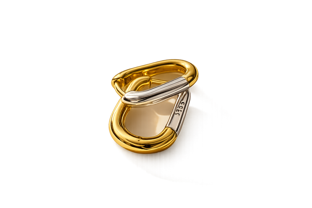 A gold and silver-tone metal carabiner clip, shown open on a clean white background.