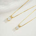 Two gold necklaces with diamond pendants on a white background