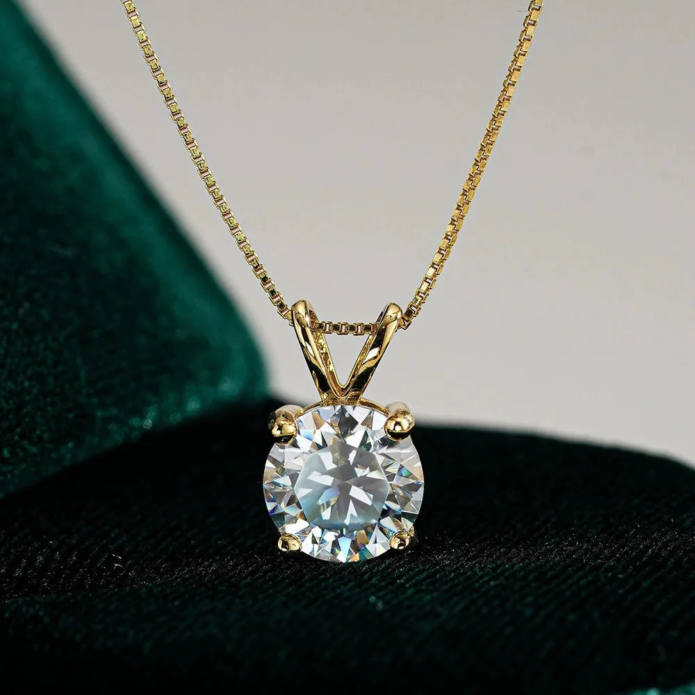 Gold necklace with a round diamond pendant on a dark surface