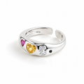 A silver adjustable ring featuring three heart-shaped gemstones in pink, yellow, and clear rectangular settings, with a small black heart detail, shown on a white background.