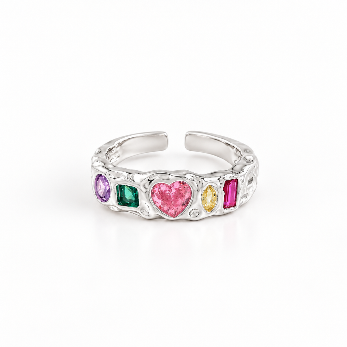 A silver-toned open band ring featuring a row of colorful gemstones, including a prominent pink heart-shaped stone, a green square stone, a purple oval stone, a yellow marquise stone, and a magenta rectangular stone, set against a clean white background.